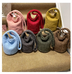 Détail de sacs seaux en laine bouclée de sept couleurs sur un escalier chic