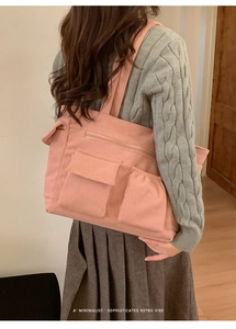 Pink corduroy tote bag detail showing multi-pocket design and ribbed texture