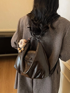Large capacity dark coffee slouchy tote bag with plush charm shown on female model