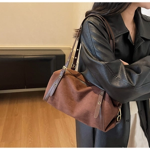 Detail of vintage brown matte leather shoulder bag with adjustable strap and gold hardware