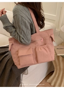 Detail of pink corduroy tote bag with multiple pockets and soft ribbed texture finish