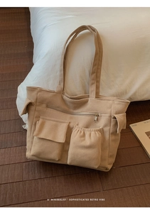 Detail of beige corduroy tote bag showing ribbed texture and front utility pockets