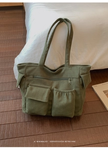 Detail of corduroy shoulder bag showing dual front pockets and soft ribbed texture
