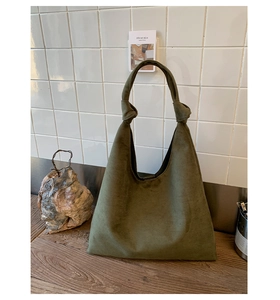 Detailed macro view of olive green suede tote bag showing soft texture and knot handle detail