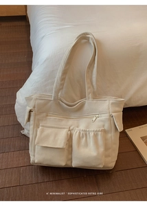 Detail of beige corduroy tote bag with multi-pocket design and long shoulder straps