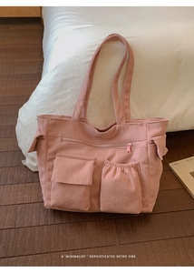 Detailed view of pink corduroy tote bag showing side pockets and textured fabric