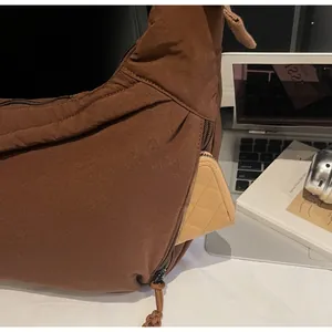 Close-up of side zipper pocket on a brown dumpling bag with a wallet inside