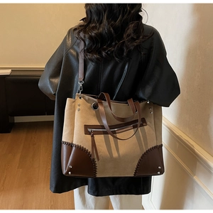 Detail of vintage tote bag showing retro canvas texture and brown leather stitching