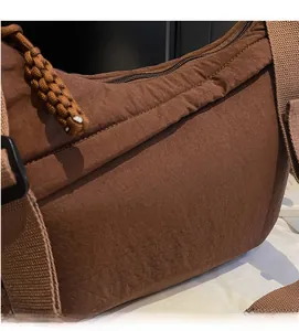 Close-up of tan nylon material with a textured finish and durable woven zipper puller