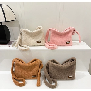 Multiple colors of soft sherpa fleece crossbody bags with leather logo detail on display