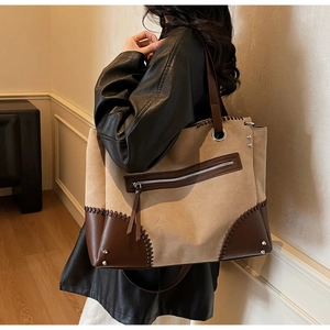 Dettaglio della borsa tote vintage in pelle scamosciata con cuciture, rivetti e zip
