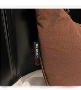 Close-up of brown nylon shoulder bag featuring the YOU JI BEAR fabric label detail