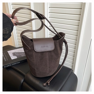 Close-up of matte suede bucket bag texture with brand logo and premium leather details