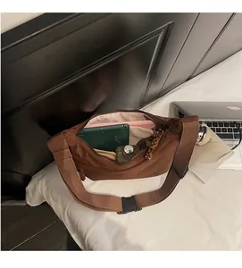 Detail view of large brown nylon crossbody bag showing spacious interior for daily items
