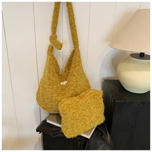 Detail view of mustard yellow wool hobo bag with matching zipper coin pouch and brand label
