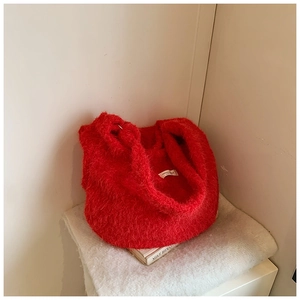Close-up of fluffy red wool tote bag featuring a brand label and soft plush texture