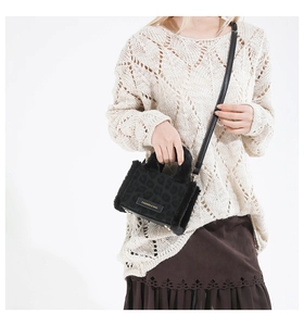 Dettaglio della mini borsa a tracolla nera con texture leopardata e finiture in peluche