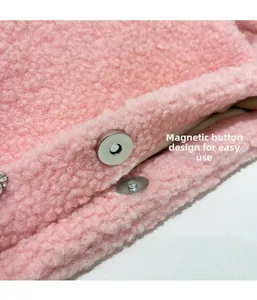 Detail view of pink sherpa bag featuring a circular silver magnetic snap closure