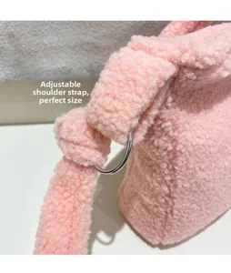 Close-up of pink faux shearling bag with adjustable strap and silver metal ring hardware
