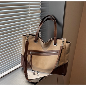Close-up of vintage khaki tote bag showing contrast stitching and leather shoulder straps