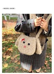 Dettaglio della borsa tote in peluche beige con ricamo a forma di cane e fiocco rosso