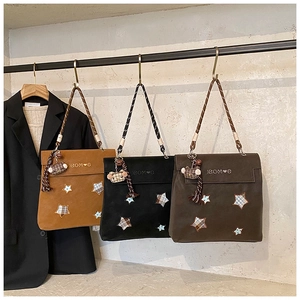 Détail de trois sacs à dos vintage étoilés avec bretelles tressées et breloques à carreaux
