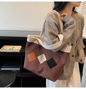 Detail of vintage tote bag featuring suede textures and corduroy handles in autumn tones