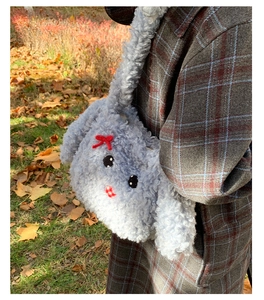 Dettaglio della borsa tote in peluche azzurro con musetto di agnello e fiocco rosso ricamato
