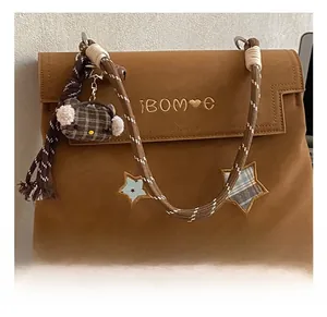 Détail du sac à dos marron vintage avec écussons étoiles et poignée en corde tressée