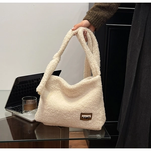 Detail of soft cream white faux fur texture on shoulder bag with brown leather TXBD patch