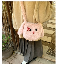 Dettaglio della borsa tote in peluche rosa con lunghe orecchie su una modella