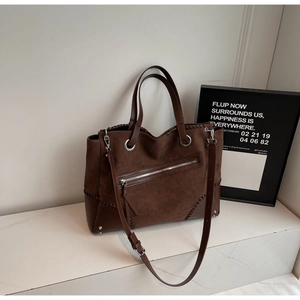 Detail view of brown large tote bag with mixed textures and decorative stitching
