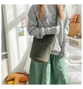 Détail du sac fourre-tout en polaire vert mousse avec large bandoulière pour l'automne