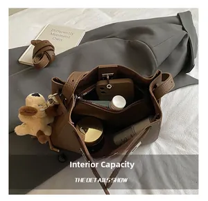 Brown lychee leather bucket bag showing large internal capacity with various essentials