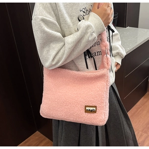 Detail view of pink plush crossbody bag with fuzzy lamb wool texture and leather label