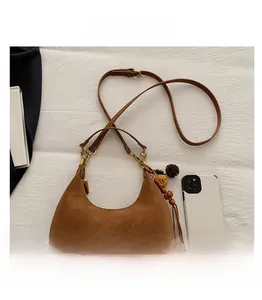 Brown suede hobo bag shown with a mobile phone to demonstrate the portable compact size