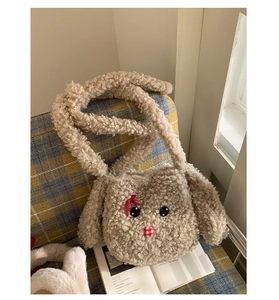 Dettaglio della borsa a tracolla a forma di coniglio in morbido peluche beige con fiocco