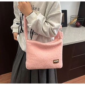 Detail of pink faux fur shoulder bag featuring a brown leather TXBD brand label