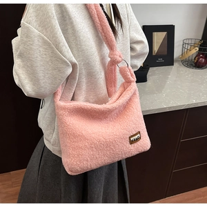 Detail of pink teddy faux fur crossbody bag featuring a decorative knot and metal ring