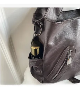 Detail view of large dark brown tote bag showing the side pocket for water bottle storage