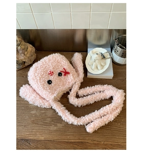 Dettaglio della borsa tote in peluche rosa con viso carino e decorazione con fiocco rosso