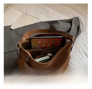 Macro view showing the large interior capacity and zipper pocket of this brown tote bag