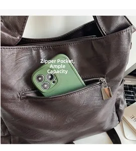 Detail of deep brown leather tote bag showing a secure back zipper pocket for smartphones