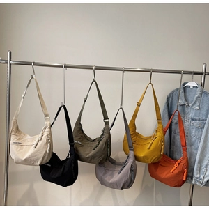 Selection of colorful half-moon nylon crossbody bags with adjustable straps and logo print