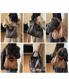 Detail view of large leather tote bag in dark brown and caramel with functional zippers