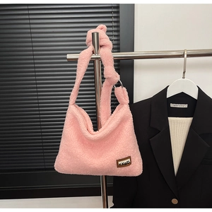 Detailed view of pink fuzzy teddy tote bag with TXBD leather patch and knotted strap