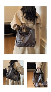 Detail view of coffee brown faux leather tote showing adjustable strap and shoulder wear