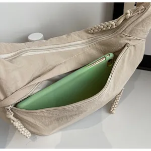Close-up of beige canvas bag side pocket with woven zipper showing phone storage
