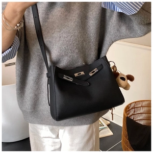 Detail of black pebbled leather bucket bag with silver buckle and puppy charm