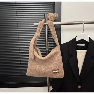 Detail of beige fleece tote bag featuring a stylish knotted shoulder strap and brand label